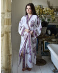 Powell Craft Purple Large Floral Block Print naisten kimonoaamutakki ikkunan edessä seisovan naisen yllä.