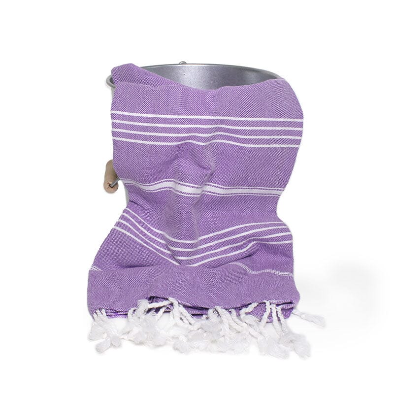 Saunatonttu by Kaurilan saunan Elsan Hamam-pyyheliina sävyssä Luumu, jossa violetilla pohjalla harvassa valkoisia raitoja ja päissä valkoiset kierrehapsut.