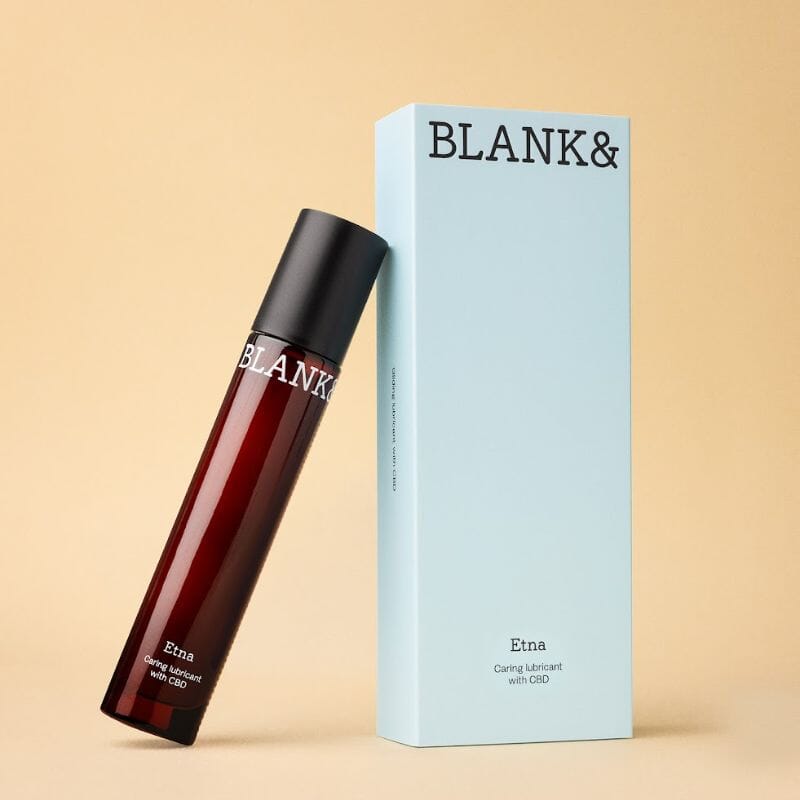 Etna – Hoitava CBD liukuvoide 50 ml brändiltä Blank&. Punaista lasia oleva pullo nojaa vedensiniseen kartonkipakkaukseen.