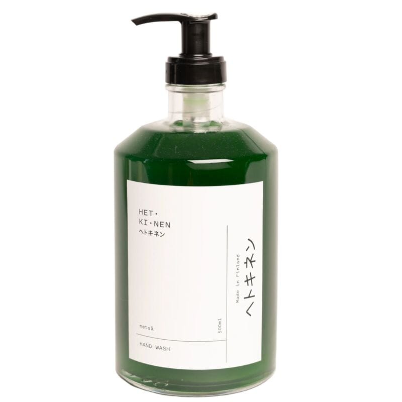 Hetkinen nestemäinen syvän vihreä käsisaippua 'Metsä' kirkkaassa pumppupullossa, jossa tyylikäs valkoinen etiketti.