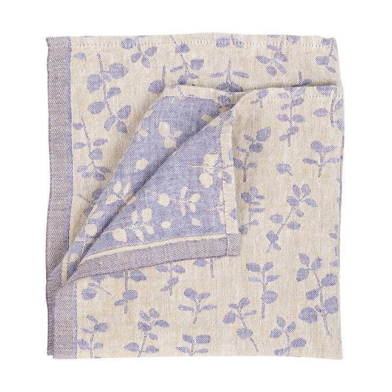 Lapuan Kankurit Meirami-servietti sävyssä  kulta-laventeli, jossa vaalealla pohjalla laventelisävyisiä meiraminoksia. Kääntöpuolella värit toisin päin.  Koko 46 x 46cm 