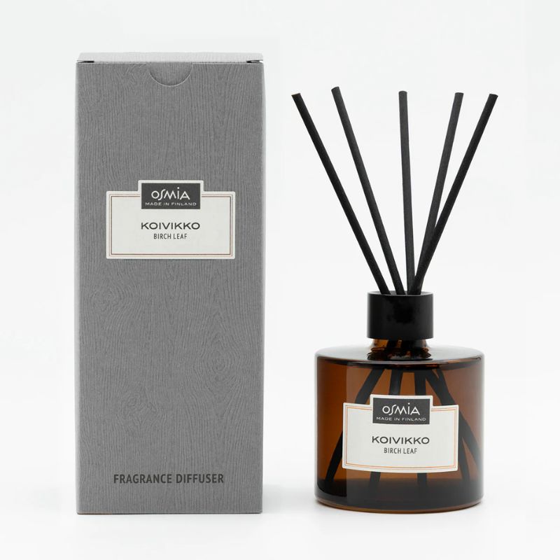 Osmian Koivikko-huonetuoksun lahjapakkaus, johon kuuluu 250ml tyylikäs ruskea lasipullo, mustat tuoksutikut ja harmaa pahvipakkaus.
