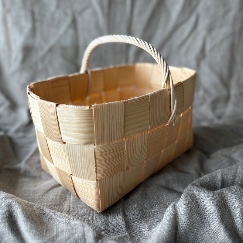 Pienempi, suorakaiteen mallinen käsintehty pärekori, jossa näkyy käsittelemättömän männynpäreen luonnollinen ja rouhea pinta.