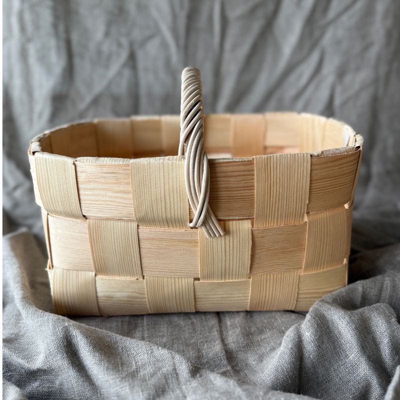 Pieni pärekori sivusta kuvattuna, jossa näkyy tukeva kantokahva, jonka punokset alittuvat kauniisti luoden yksityiskohtaisen ja perinteisen ilmeen.