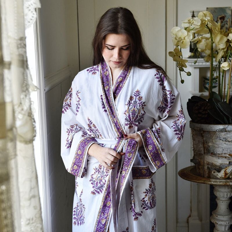 Powell Craft Purple Large Floral Block Print naisten kimonoaamutakki vaatteen yksityiskohtia tutkiskelevan naisen yllä.
