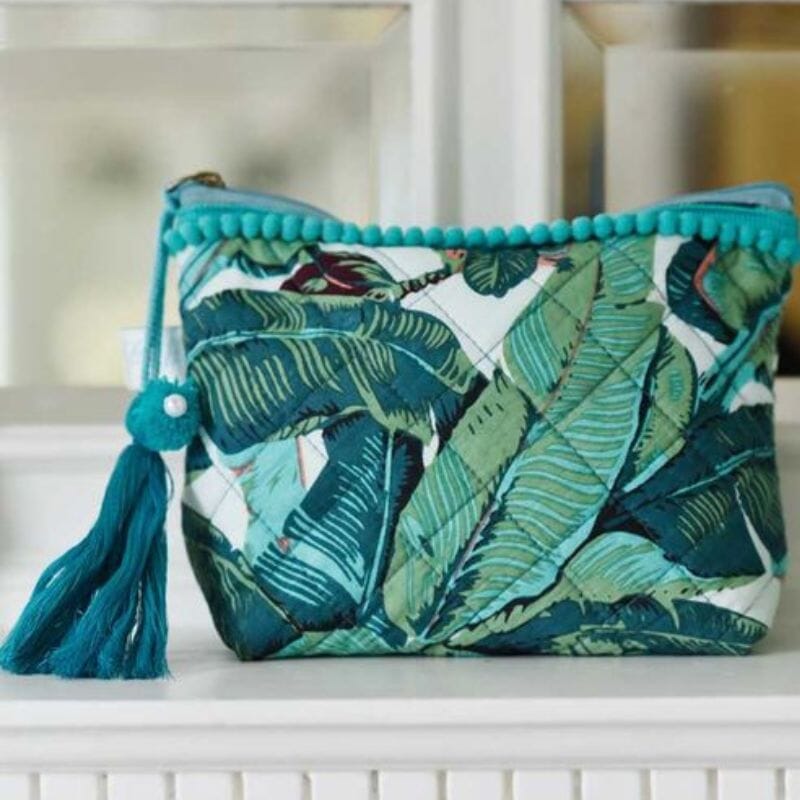 Powell Craft Green Leaf -toilettilaukku, jossa vihreitä lehtikuvioita, soma pampulareuna ja tupsukoriste vetoketjun vetimessä.