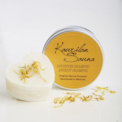 Kaurilan saunan 90 gramman aprikoosi-palashampoo ja sen metallinen rasia, jossa on keltainen etiketti.
